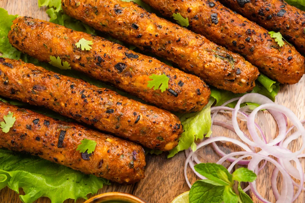 Golden and slightly chared sheek kebab with onions on the side